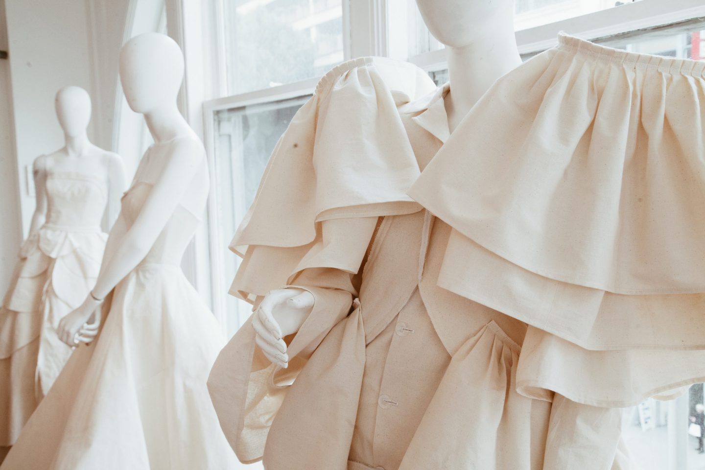 four mannequins displaying a ruffled fashion design