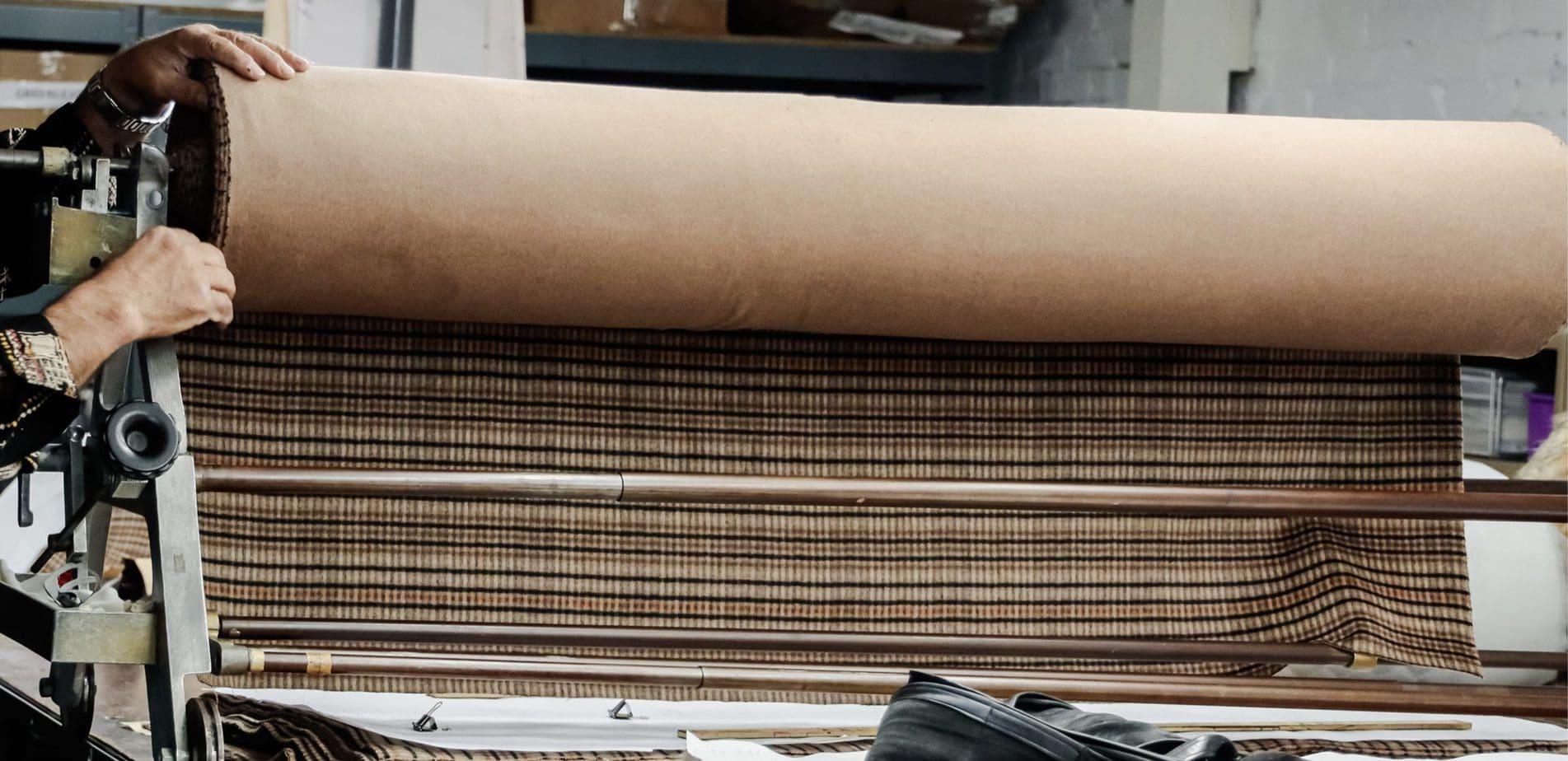 Los Angeles clothing manufacturer unfurling striped fabric used for bespoke clothing design