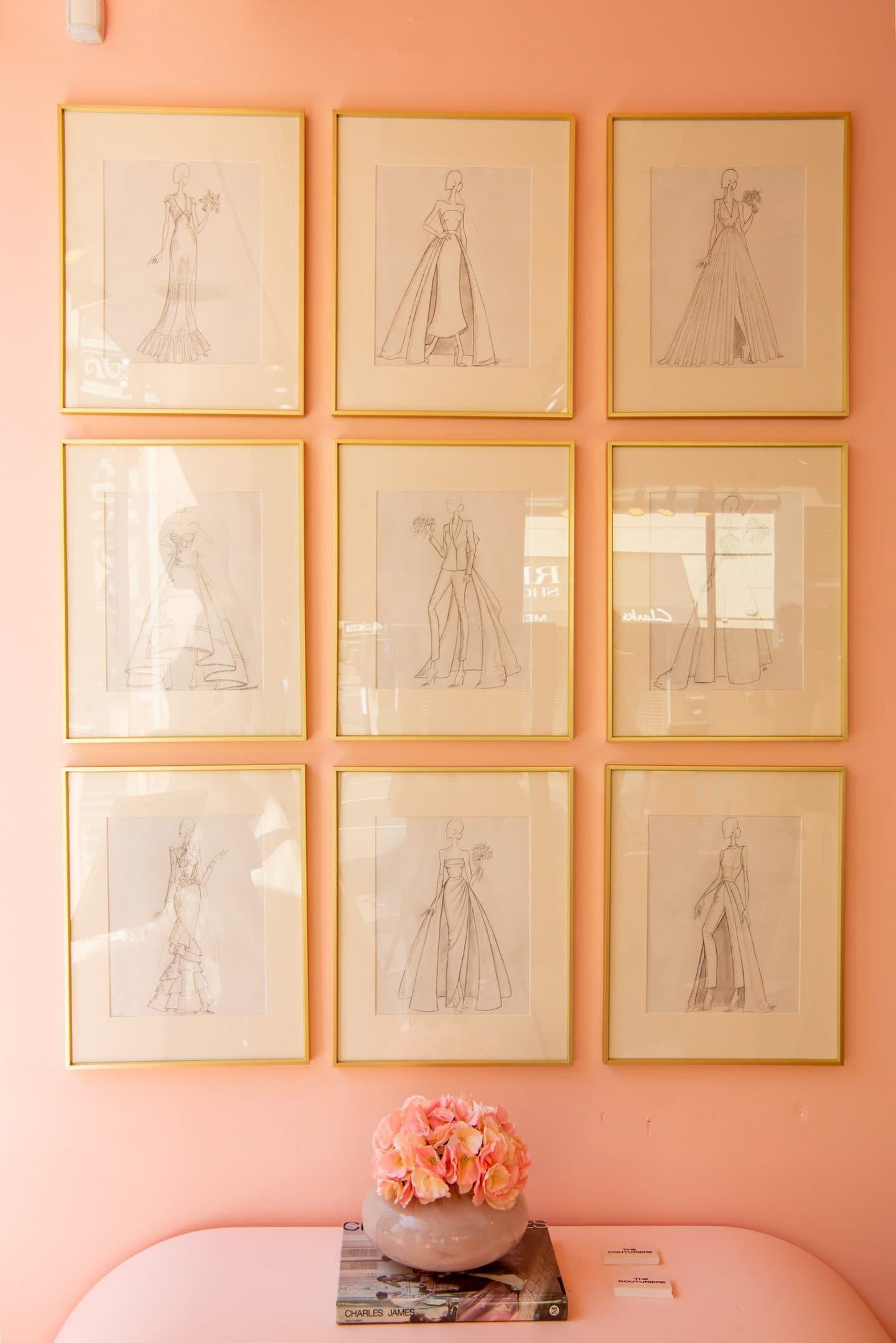 pink wall with nine fashion drawings hung on the wall